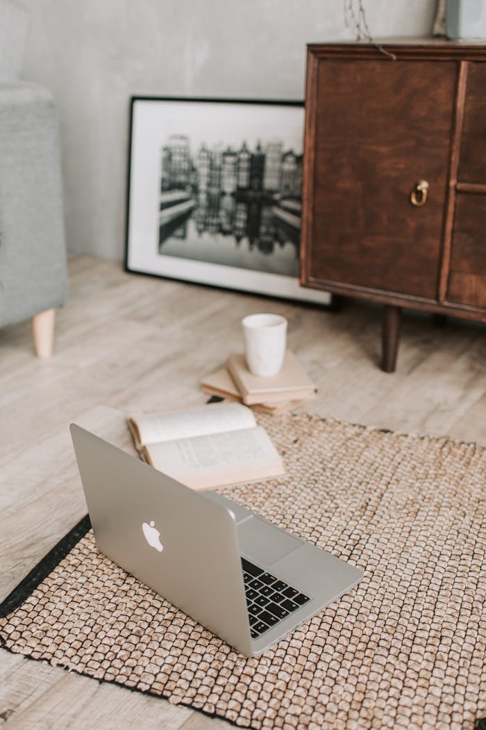 services-01 A serene workspace with a laptop, open book, and coffee cup on a textured rug, ideal for remote work.